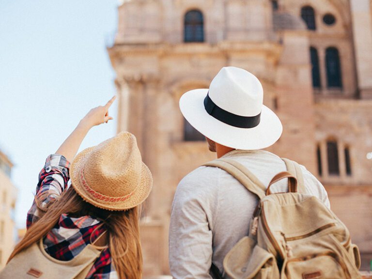 Couple exploring village architecture with church in the background