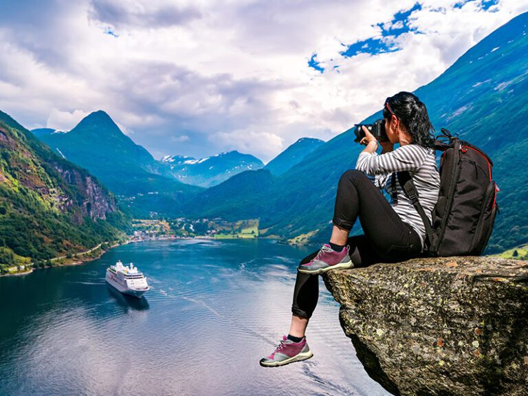 Photographer capturing the breathtaking sea view from a mountain peak