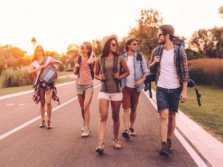 Group of friends hiking through a forested road